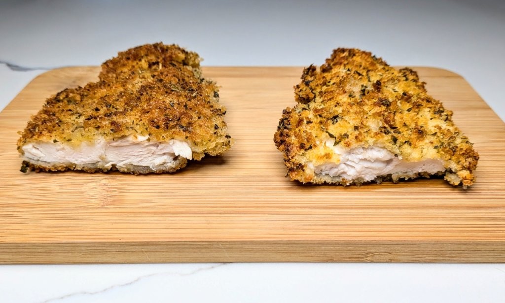 A close up of two chicken schnitzels cut in half: the left one is air fried, the right is shallow fried