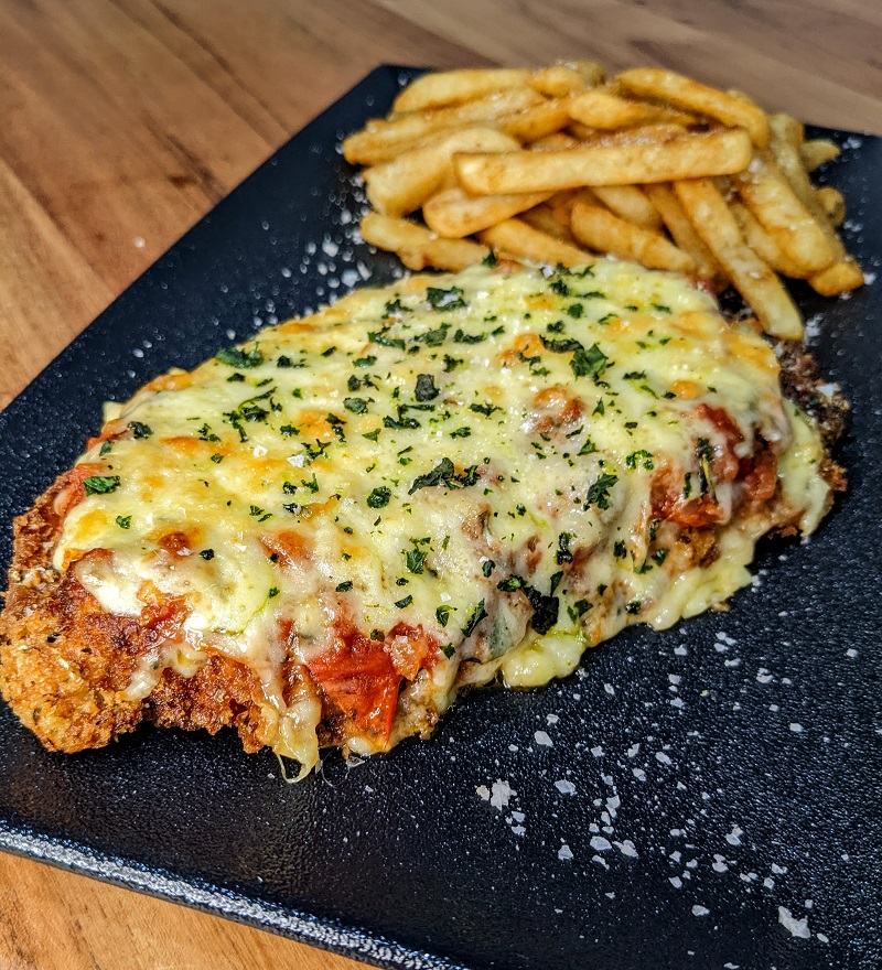 A crispy chicken schnitzel topped with lashings of napoli sauce and melted cheese